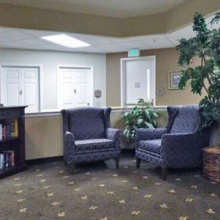 A cozy lobby with armchairs and a bookshelf in a welcoming setting.