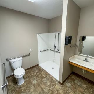 Accessible bathroom with a shower, toilet, and sink.