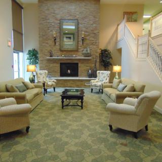 A cozy living room featuring a central fireplace, surrounded by comfortable seating and elegant decor.