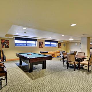 A spacious game room featuring a pool table and seating area.