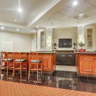 A modern bar area with seating and stylish lighting.