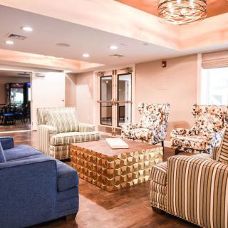 A cozy living room with patterned armchairs and a central coffee table.