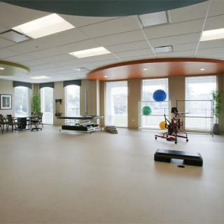 A spacious rehabilitation center with exercise equipment and large windows.