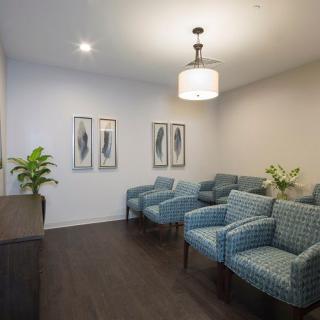 A cozy waiting room with blue patterned chairs and wall art.