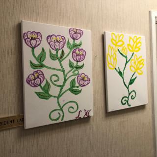 Colorful floral paintings displayed on a wall.