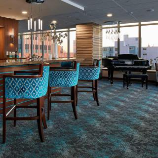 A modern bar area with stylish seating and large windows offering a view.