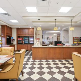 A bright and spacious dining area with a checkered floor and wooden furniture.