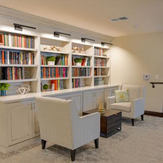 A cozy reading nook featuring a well-organized bookshelf and comfortable seating.