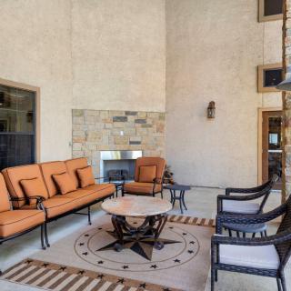 A modern outdoor patio with comfortable seating and a fireplace.