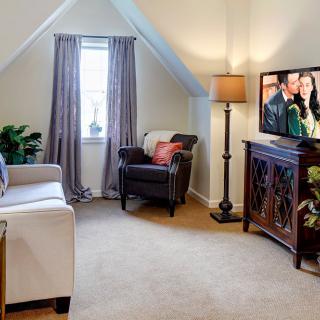 Cozy attic living room with a comfortable seating area and a TV.