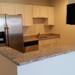 A modern kitchen with stainless steel appliances and granite countertops.