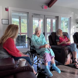 An intimate moment shared among three women in a cozy indoor setting, highlighting the importance of companionship and community.