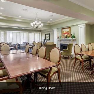 A spacious dining room with elegant furnishings and a fireplace.