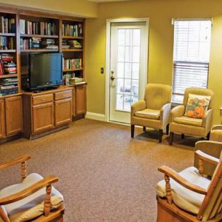 A cozy living room with bookshelves, a television, and comfortable seating.