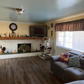 A cozy living room featuring a fireplace, television, and a comfortable couch with decorative pillows.