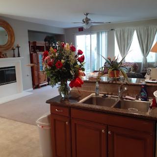 A cozy open-concept kitchen and living room with a floral centerpiece and a fireplace.