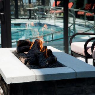 A cozy outdoor fire pit setup next to a swimming pool, perfect for relaxation.