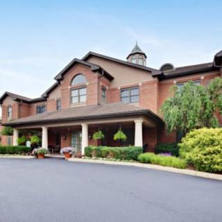 A brick building with a landscaped entrance and driveway.