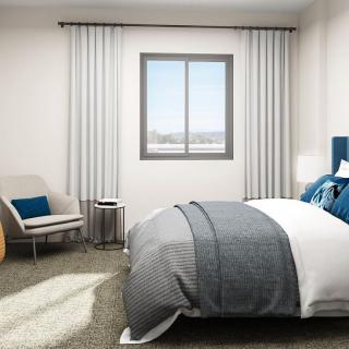 A modern and minimalist bedroom featuring a comfortable bed, a cozy chair, and neutral tones.