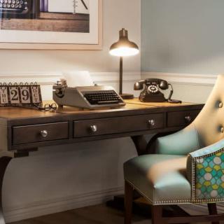 A cozy vintage workspace featuring a typewriter and rotary telephone.