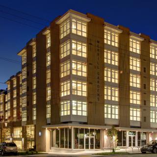 A modern apartment building illuminated at night, showcasing its architectural design.