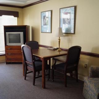 A cozy living room setup with a table, chairs, and an old-style TV.