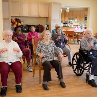 A group of seniors engaging in a seated exercise session at a community center.