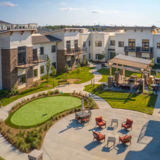 A modern residential complex with outdoor seating and landscaped gardens.