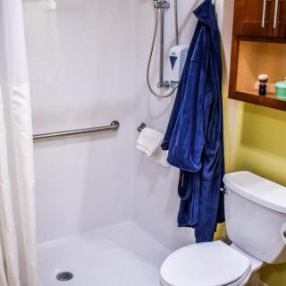 A modern bathroom with a shower area, towel rail, and toilet.