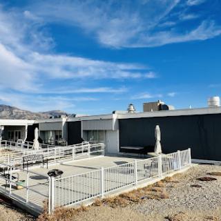 A modern building featuring a fenced outdoor area under a clear blue sky.