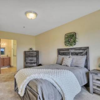 A cozy bedroom with a neatly made bed and stylish decor.