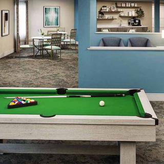 A modern game room featuring a pool table and a comfortable seating area.
