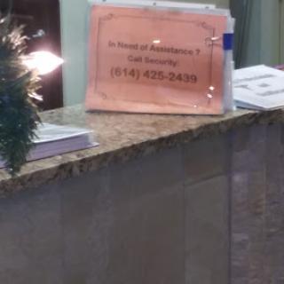 A sign at a reception desk providing contact information.