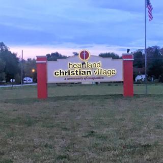 A sign for a Christian organization at dusk.