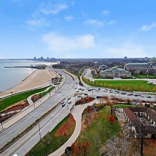 Aerial view of a waterfront cityscape with roads and a beach.