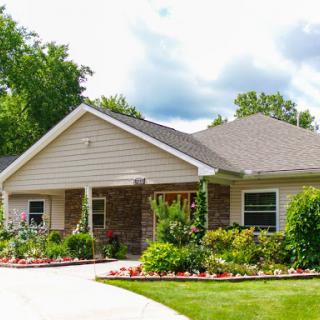 A charming single-story house with a landscaped garden and a welcoming front porch.