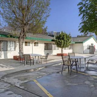 Outdoor seating area at a motel with chairs and tables on a paved surface.