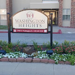 Entrance sign for Washington Heights, featuring a well-kept floral arrangement.