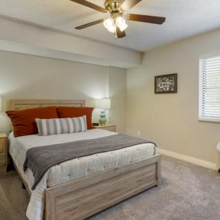 A modern bedroom with a comfortable bed, bedside lamps, and a ceiling fan.