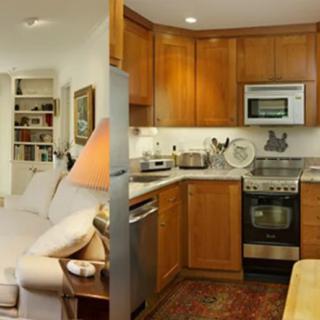 A cozy living room connected to a compact kitchen with wooden cabinets and modern appliances.