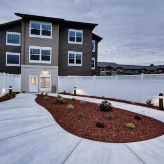 A modern residential building with a landscaped front pathway.