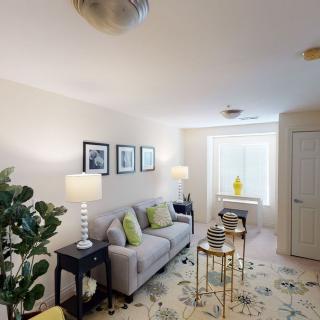 A cozy living room with modern decor, featuring a comfortable sofa, stylish coffee tables, and elegant lamps.