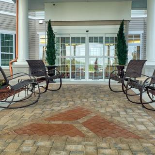 A welcoming porch area with rocking chairs and potted plants.