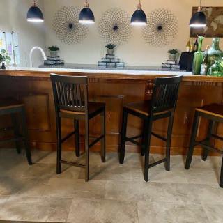 A cozy kitchen bar with wooden stools and pendant lighting.