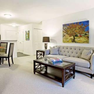 A modern living room featuring a stylish sofa and coffee table, complemented by wall art and ambient lighting.