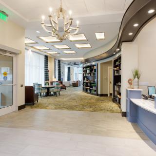 A modern office lobby with a chandelier and reception desk.