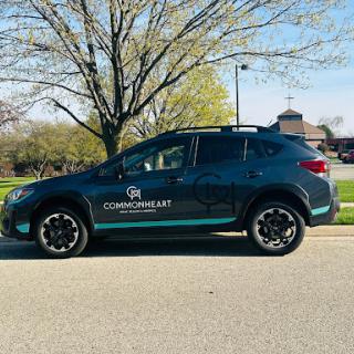 A parked SUV showcasing a modern design, surrounded by greenery on a sunny day.