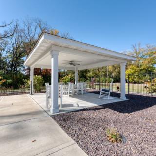 A cozy outdoor gazebo with seating under a clear blue sky.