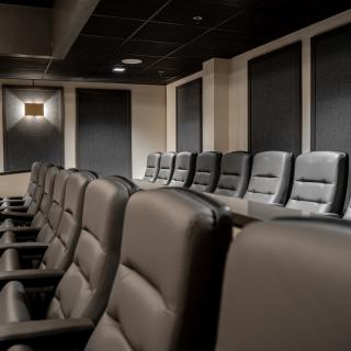 An empty theater room with rows of comfortable seats.