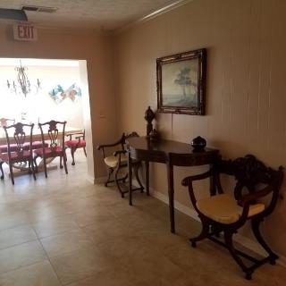 A hallway with elegant furniture leading to a dining area.